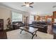 Spacious living room with hardwood floors, leather furniture, fireplace, ceiling fan and view of kitchen at 314 Pulaski Sw Dr, Concord, NC 28027
