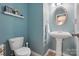 Charming powder room with a pedestal sink, framed mirror, and blue walls at 314 Pulaski Sw Dr, Concord, NC 28027