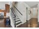 A home stairway with black wooden steps and railing, light walls, and dark wood flooring, seamlessly connecting levels at 314 Pulaski Sw Dr, Concord, NC 28027