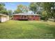 Large backyard view showcasing the deck, red brick exterior, and plenty of green space at 3430 Stokes Ferry Rd, Salisbury, NC 28146