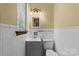 Clean, quaint bathroom featuring a tiled wall, sink, mirror and toilet at 3430 Stokes Ferry Rd, Salisbury, NC 28146