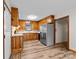 Kitchen with wood cabinets, stainless steel refrigerator, and wood-look vinyl flooring at 3430 Stokes Ferry Rd, Salisbury, NC 28146