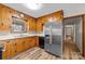 Well-lit kitchen with wooden cabinets, stainless steel refrigerator, and wood-look vinyl flooring at 3430 Stokes Ferry Rd, Salisbury, NC 28146