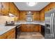 Kitchen with wood cabinets, modern appliances, solid surface countertops, and wood-look vinyl flooring at 3430 Stokes Ferry Rd, Salisbury, NC 28146