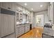Kitchen featuring sleek grey cabinets, stainless steel appliances, hardwood flooring, and pantry at 4020 Barclay Downs Dr, Charlotte, NC 28209