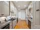 Kitchen featuring sleek grey cabinets, stainless steel appliances, and hardwood flooring at 4020 Barclay Downs Dr, Charlotte, NC 28209