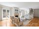 Bright living room with fireplace, white furniture, hardwood floors, and access to outdoor patio at 4020 Barclay Downs Dr, Charlotte, NC 28209