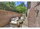 Spacious patio with brick walls, stone flooring, comfortable seating, and an outdoor grill at 4020 Barclay Downs Dr, Charlotte, NC 28209