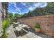 Back patio boasts stone flooring, brick walls, outdoor seating, lush plants, and a blue sky view at 4020 Barclay Downs Dr, Charlotte, NC 28209