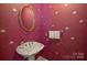 Unique powder room with bold wallpaper, a stylish sink, and gold mirror at 4020 Barclay Downs Dr, Charlotte, NC 28209