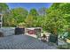 Backyard with brick patio featuring a hot tub, fire pit area, and surrounding greenery at 4501 Montibello Dr, Charlotte, NC 28226