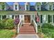 Inviting home entrance with brick steps, wood door, and lush landscaping at 4501 Montibello Dr, Charlotte, NC 28226