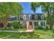 Charming home featuring a manicured lawn and brick entryway, framed by mature trees at 4501 Montibello Dr, Charlotte, NC 28226