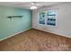 Carpeted bedroom featuring a window with blinds and a light-green accent wall at 4656 Chaucer Nw Pl, Concord, NC 28027