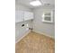 Tiled laundry room featuring a window, overhead cabinets, and utility connections at 4656 Chaucer Nw Pl, Concord, NC 28027