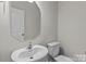 Clean and simple half bathroom with a modern sink and mirror, perfect for guests in a neutral color palette at 5024 Colline Ct, Charlotte, NC 28216