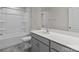 Bright bathroom featuring a shower-tub combo, gray cabinets, and a large mirror at 5024 Colline Ct, Charlotte, NC 28216