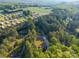Aerial view of the property with mature trees surrounding it and other homes in the distance at 5039 Pine Springs Dr, Bessemer City, NC 28016
