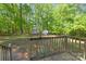 A view of the backyard, wood deck, and sheds surrounded by lush trees at 5039 Pine Springs Dr, Bessemer City, NC 28016