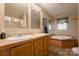 Bathroom with a double sink vanity, a soaking tub, and neutral decor at 5039 Pine Springs Dr, Bessemer City, NC 28016