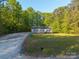Quaint home on a spacious lot with a long driveway surrounded by lush greenery at 5039 Pine Springs Dr, Bessemer City, NC 28016