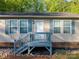 Charming home featuring light siding, blue shutters, and a welcoming front porch with a wooden railing at 5039 Pine Springs Dr, Bessemer City, NC 28016
