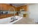 Well-lit kitchen featuring wooden cabinets, white appliances, and a modern sink with a chrome faucet at 5039 Pine Springs Dr, Bessemer City, NC 28016