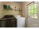 Functional laundry room featuring a washer, dryer, and storage shelves at 5039 Pine Springs Dr, Bessemer City, NC 28016