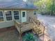 Back of house with wood deck, railing, and access stairs overlooking the peaceful yard and surrounding trees at 5039 Pine Springs Dr, Bessemer City, NC 28016