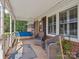 Inviting front porch featuring a blue swing, comfortable wicker chairs, and views of a beautifully landscaped yard at 5159 Taxahaw Rd, Lancaster, SC 29720