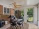 Enclosed sunroom with brick wall, ceiling fan, a table, and access to the backyard at 5159 Taxahaw Rd, Lancaster, SC 29720