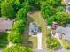 Aerial view of modern two-story home with dark roof, long driveway, and grassy front lawn surrounded by mature trees at 5227 Pinebrook Dr, Charlotte, NC 28208