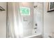 Bright bathroom featuring a shower-tub combination with white marble tile and a window at 5227 Pinebrook Dr, Charlotte, NC 28208