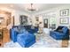 Open concept living room with modern decor, a comfortable blue sofa, and seamless flow to the dining area and kitchen at 5227 Pinebrook Dr, Charlotte, NC 28208