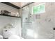 Modern shower with white tile, glass doors, and sleek fixtures, complete with shelving at 5227 Pinebrook Dr, Charlotte, NC 28208