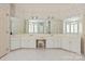 Luxury primary bathroom with dual sinks, vanity seating, and elegant wallpaper, tile floors, and large mirrors at 5335 Lower Shoal Creek Ct, Charlotte, NC 28277