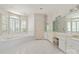 A luxurious bathroom with double sinks, a soaking tub, large mirrors, white tile flooring, and a separate toilet room at 5335 Lower Shoal Creek Ct, Charlotte, NC 28277