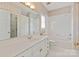 A well-lit bathroom features a shower, vanity, and neutral wallpaper with a shuttered window at 5335 Lower Shoal Creek Ct, Charlotte, NC 28277