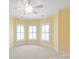 Bright carpeted bedroom featuring three shuttered windows and crown molding at 5335 Lower Shoal Creek Ct, Charlotte, NC 28277