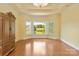 Spacious bedroom featuring hardwood floors, lake view, plantation shutters, and decorative ceiling at 5335 Lower Shoal Creek Ct, Charlotte, NC 28277