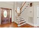 This grand foyer has hardwood floors, a wooden front door with glass, and a staircase with white risers at 5335 Lower Shoal Creek Ct, Charlotte, NC 28277
