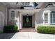 Elegant front entrance with a decorative glass door, flanked by manicured shrubs and brick steps at 5335 Lower Shoal Creek Ct, Charlotte, NC 28277