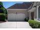 Spacious two-car garage with decorative doors and a wide driveway surrounded by green landscaping at 5335 Lower Shoal Creek Ct, Charlotte, NC 28277
