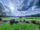 Picturesque golf course view with a serene pond and lush green landscaping on a sunny day at 5335 Lower Shoal Creek Ct, Charlotte, NC 28277