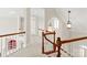 Hallway featuring wood railings, carpeted floors, decorative lighting, and white walls, located on the upper level at 5335 Lower Shoal Creek Ct, Charlotte, NC 28277