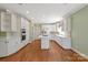 Bright kitchen featuring white cabinetry, hardwood floors, and central island at 5335 Lower Shoal Creek Ct, Charlotte, NC 28277