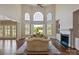 Bright living room with large windows offering views of the serene lake, a fireplace, and hardwood floors at 5335 Lower Shoal Creek Ct, Charlotte, NC 28277