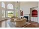 Elegant living room with views of the lake, a fireplace, and hardwood floors, perfect for relaxing at 5335 Lower Shoal Creek Ct, Charlotte, NC 28277
