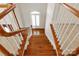Staircase features hardwood steps, white risers, and stained handrails, leading to the upper level of the home at 5335 Lower Shoal Creek Ct, Charlotte, NC 28277