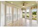 Bright sunroom featuring tile floor, ceiling fan and sliding door to the backyard pond at 5335 Lower Shoal Creek Ct, Charlotte, NC 28277